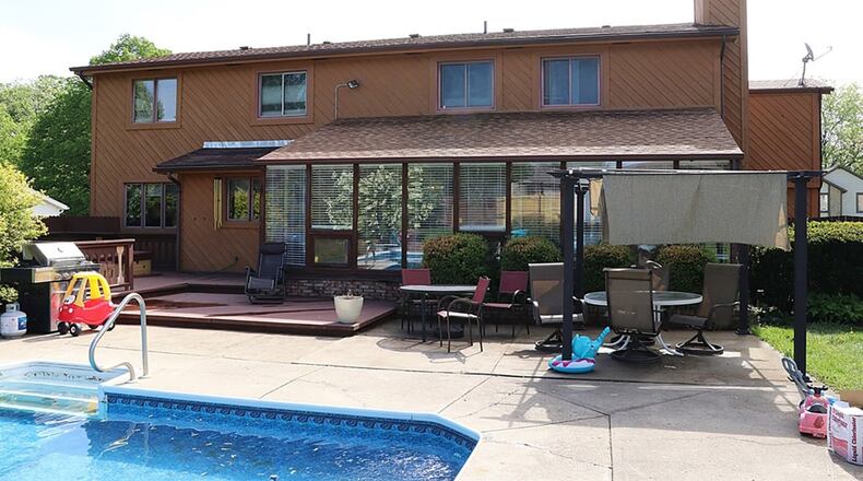 The nearly half-acre lot includes a sun room, multi-level deck and a concrete patio that wraps around an in-ground swimming pool.