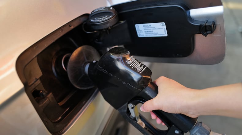 A person fills up her vehicle's gas tank at a gas station in Buffalo Grove, Ill., Thursday, March 19, 2026. (AP Photo/Nam Y. Huh)