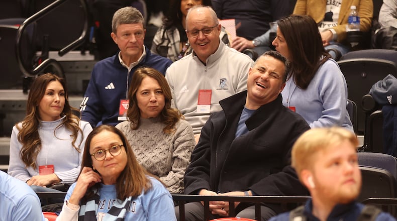 Xavier coach Sean Miller laughs before Rhode Island's game against Dayton on Saturday, Jan. 20, 2024, at UD Arena. Miller came to watch his brother Archie Miller coach. At left is Morgan Miller, Archie's wife, and Amy Miller, Sean's wife, is at center. David Jablonski/Staff