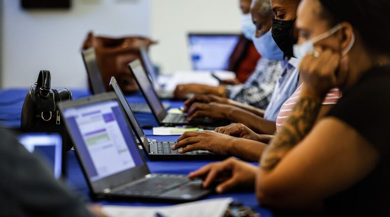 Potential Dayton Public Schools employees complete job applications at a job fair. Starting in early 2020, people who shifted from in-office work to work-from-home arrangements continued to pay city income taxes to the jurisdiction where their office was located. But the state budget bill passed this year says in 2022, people will pay income taxes based on where they actually work, not the address of their employer’s building. JIM NOELKER/STAFF