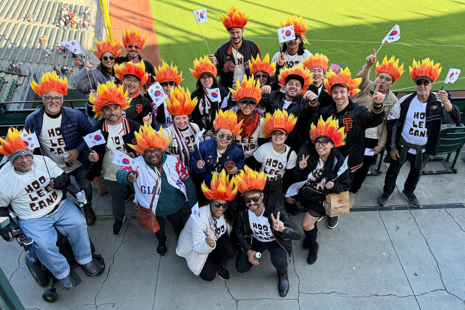Fans of San Francisco Giants' Jung Hoo Lee, who call themselves Hoo Lee Gans, pose for photos before a baseball game between the Giants and the Arizona Diamondbacks in San Francisco, Tuesday, May 13, 2025. (AP Photo/Haven Daley)