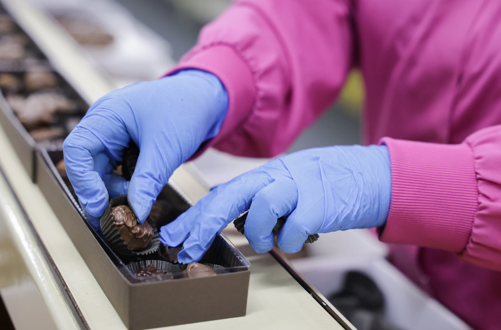 An Esther Price worker places a piece of candy into a box of assorted chocolates on Tuesday, March 3 at the company's production facility on Wayne Avenue in Dayton. The company is celebrating its 100th anniversary. BRYANT BILLING / STAFF