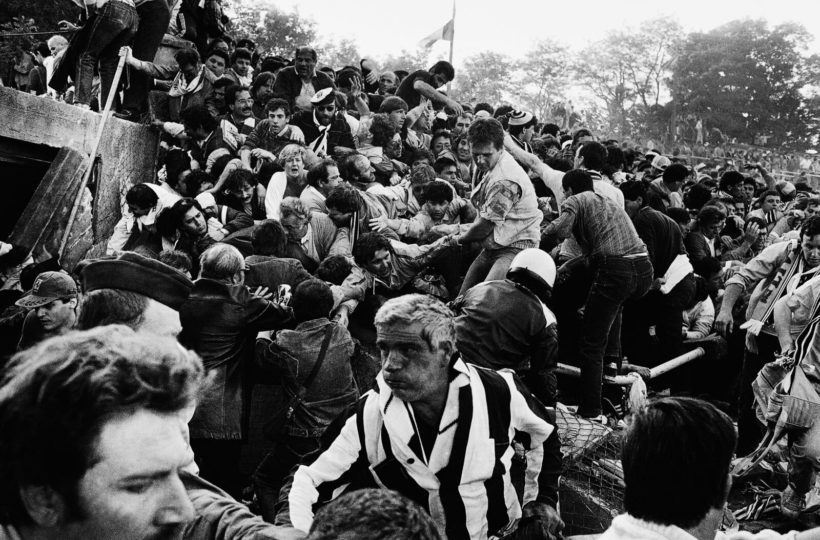 FILE - Soccer fans are crushed against a collapsing wall in the Brussels Heysel stadium just prior to the European Cup final soccer match between Liverpool and Juventus, in Brussels, Belgium, May 29, 1985. (AP Photo/Gianni Foggia, File)