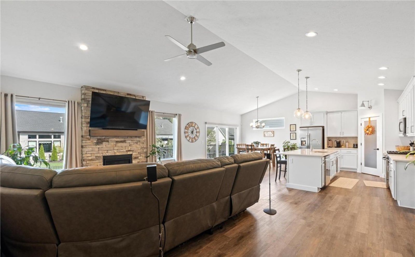 The great room, kitchen and dining area are open concept and feature luxury vinyl plank flooring throughout. There is recessed lighting in the vaulted ceiling and a stacked stone gas fireplace with wood mantel. A sliding glass door off the dining area opens to the rear deck. CONTRIBUTED