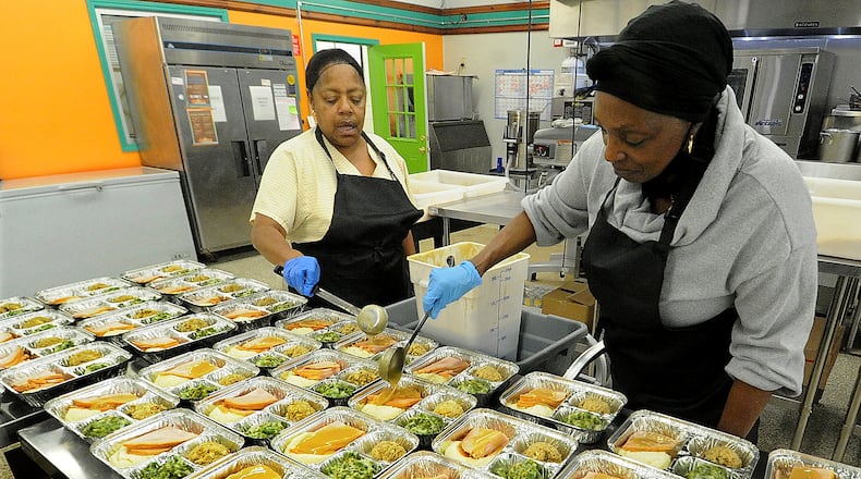 The staff at Miami Valley Meals, Cheryl Robinson, left and Marilyn Britt prepare Thanksgiving meals Monday Nov. 21, 2022. MARSHALL GORBY\STAFF