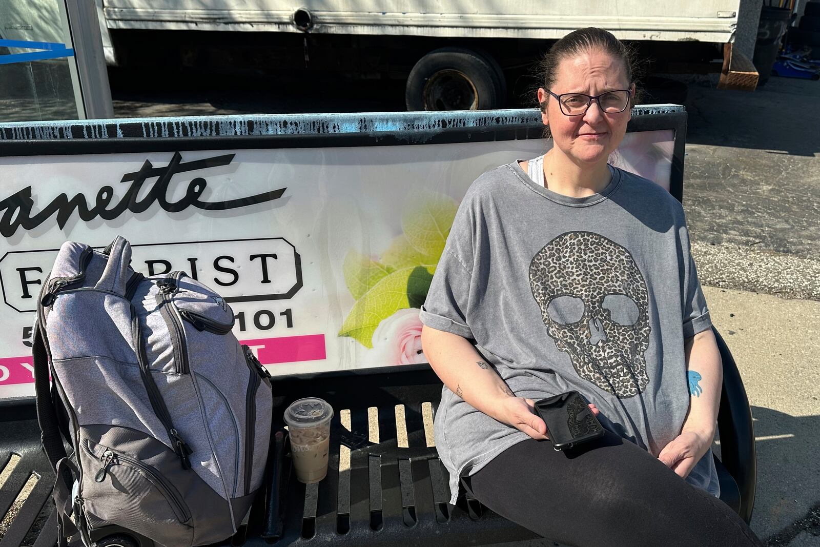 Kelly Rivard, 47, sits at a bus stop Wednesday, April 23, 2025, in Windsor, Ontario, Canada. (AP Photo/Corey R. Williams)