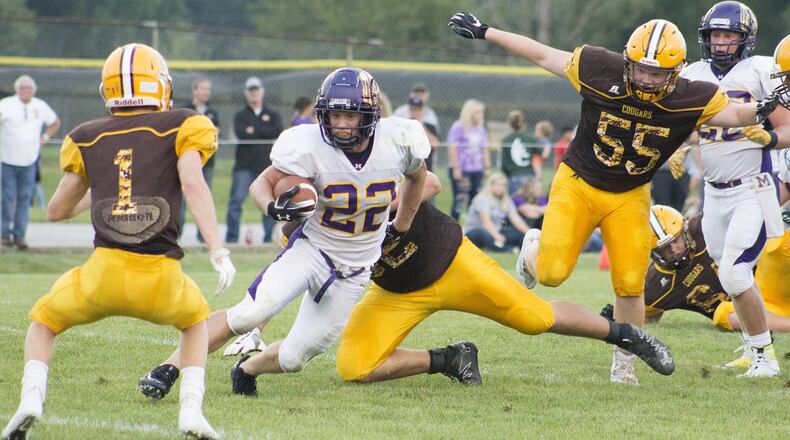 Joey Mascadri of Mechanicsburg runs through a hole in the Kenton Ridge defense toward Andrew Good, 1, and away from Brandon Collins, 55, during the season opener at Kenton Ridge. Jeff Gilbert/CONTRIBUTED