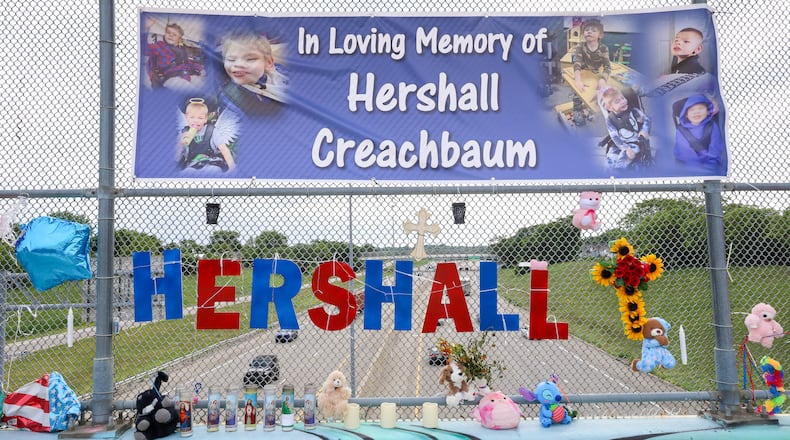 A memorial has been set up on the McClure Street bridge over U.S. Route 35 for Hershall Creachbaum, a 7-year-old who was found dead on July 12. Balloons, stuffed animals and signs are among items people have left. BRYANT BILLING / STAFF