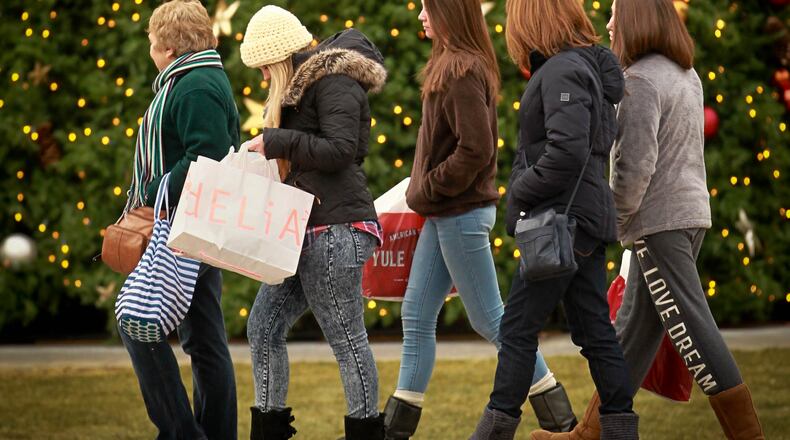 In this file photo: Black Friday shoppers walk past the large Christmas tree on the Greene Town Center in Beavercreek.