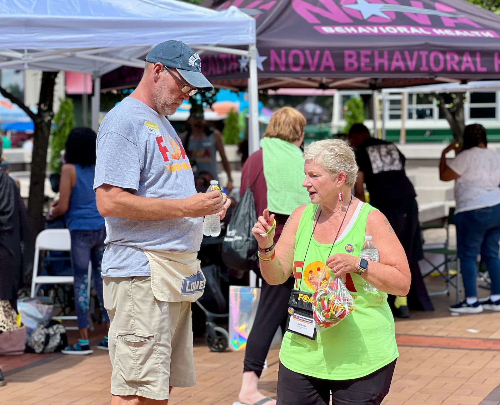 Lori Erion, the founder of Families of Addicts (FOA), passes out bracelets to rally-goers. AIMEE HANCOCK/STAFF