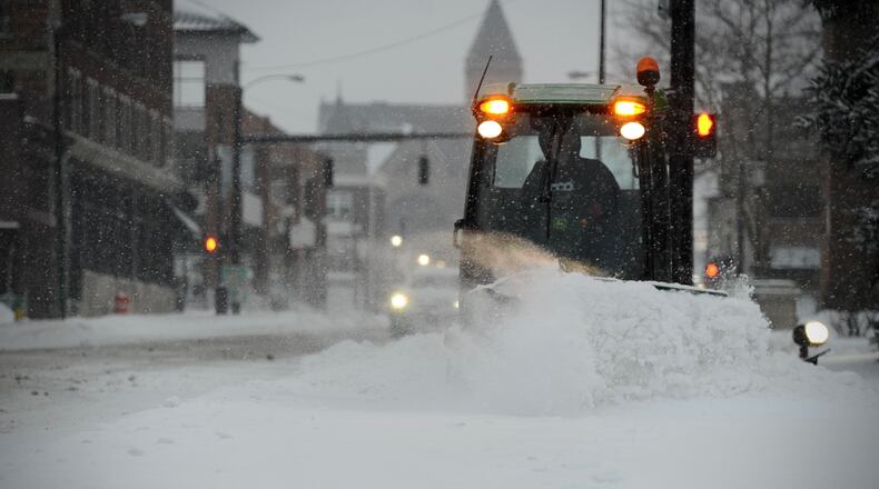 City of Springfield employees work to clear snow from the sidewalks near the post office Friday morning February 4, 2022.
