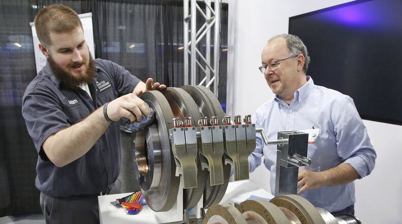 Manufacturing technician Adam Fox, left, and international sales representative Ralf Schuerl prepare centerless grinding machine parts for display at United Grinding. The company celebrated the opening of its new North American Headquarters in Miamisburg on April 17, 2018. TY GREENLEES / STAFF