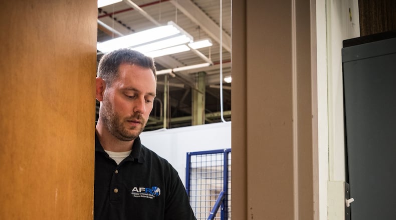 John McIntire, team lead and research psychologist in the Air Force Research Laboratory’s 711th Human Performance Wing, demonstrates how to use a portable door lock his team developed. (U.S. Air Force photo by Richard Eldridge).