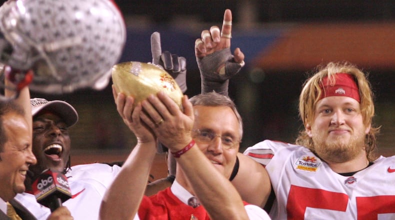 Ohio State coach Jim Tressel holds up the Fiesta Bowl trophy, as Nick Mangold, back right, and the rest of the senior on the stage, hoists the Fiesta Bowl trophy in 2005. Ron Alvey/Staff