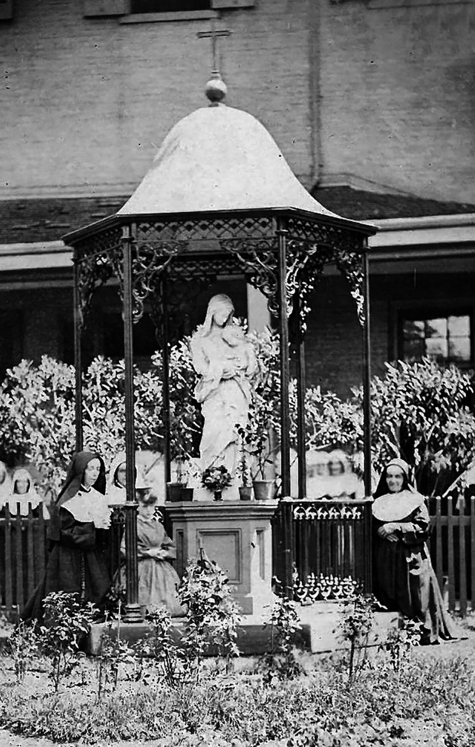 Sisters of Notre Dame de Namur gather at a statue of Virgin Mary in an undated photograph taken at Notre Dame Academy in Dayton. PHOTO COURTESY OF CHAMINADE JULIENNE CATHOLIC HIGH SCHOOL