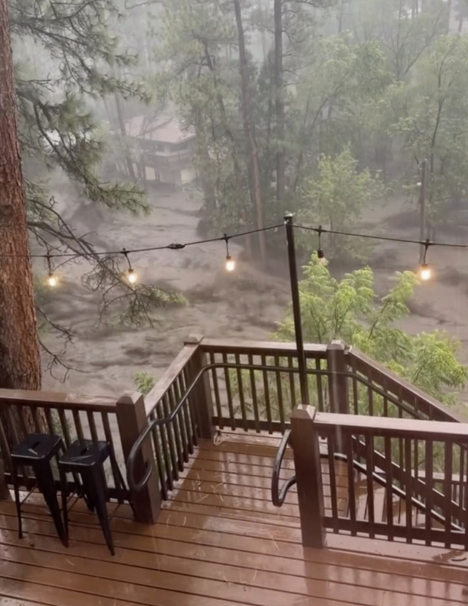 In this image taken from video, flash flooding is seen behind a house in Ruidoso, N.M., Tuesday, July 8, 2025. (Kaitlyn Carpenter via AP)