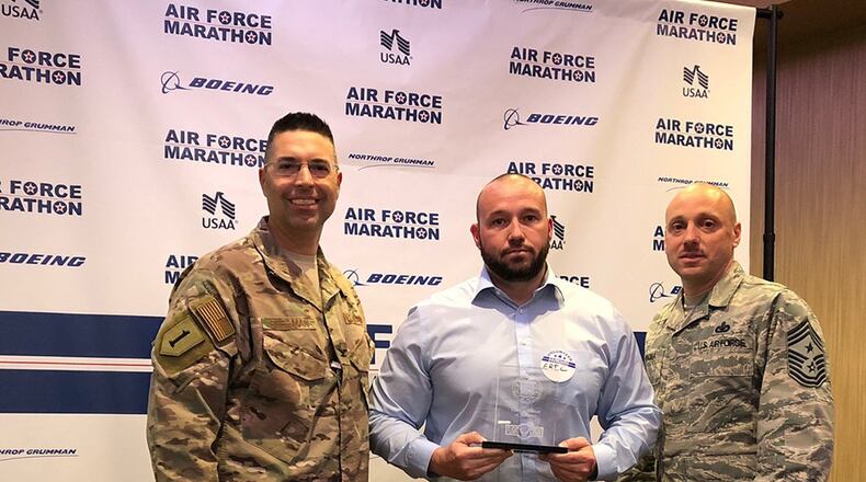Col. Thomas Sherman (left), 88th Air Base Wing and installation commander, and Chief Master Sgt. Stephen Arbona, 88 ABW command chief, present the Air Force Marathon Expo Volunteer of the Year award to Eric Hoehne at a volunteer reception held Oct. 17 at Soin Medical Center. (Courtesy photo)