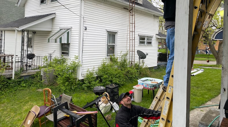 Stephen Valentine works on Marilyn Watson’s gutters at her home in Madden Hills on Saturday. Jake Riley held the ladder steady for Valentine. Watson’s home needed several repairs for her to continue to live in it. The work was done through Rebuilding Together Dayton, a local nonprofit, and the house workers were from Wilcon Corporation. EILEEN McCLORY STAFF