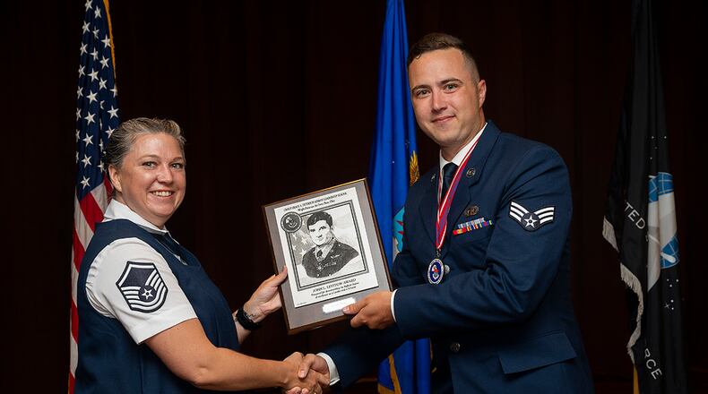 Master Sgt. Dominique Hix, Air Force Sergeants Association, presents Airman Arthur Marais, National Air and Space Intelligence Center, with the John L. Levitow Award at the Chief Master Sgt. Grace A. Peterson Airman Leadership School Class 22-E graduation ceremony on June 16, at Wright-Patterson Air Force Base, Ohio. The John L. Levitow Award goes to the class’s top graduate. U.S. AIR FORCE PHOTO/R.J. ORIEZ