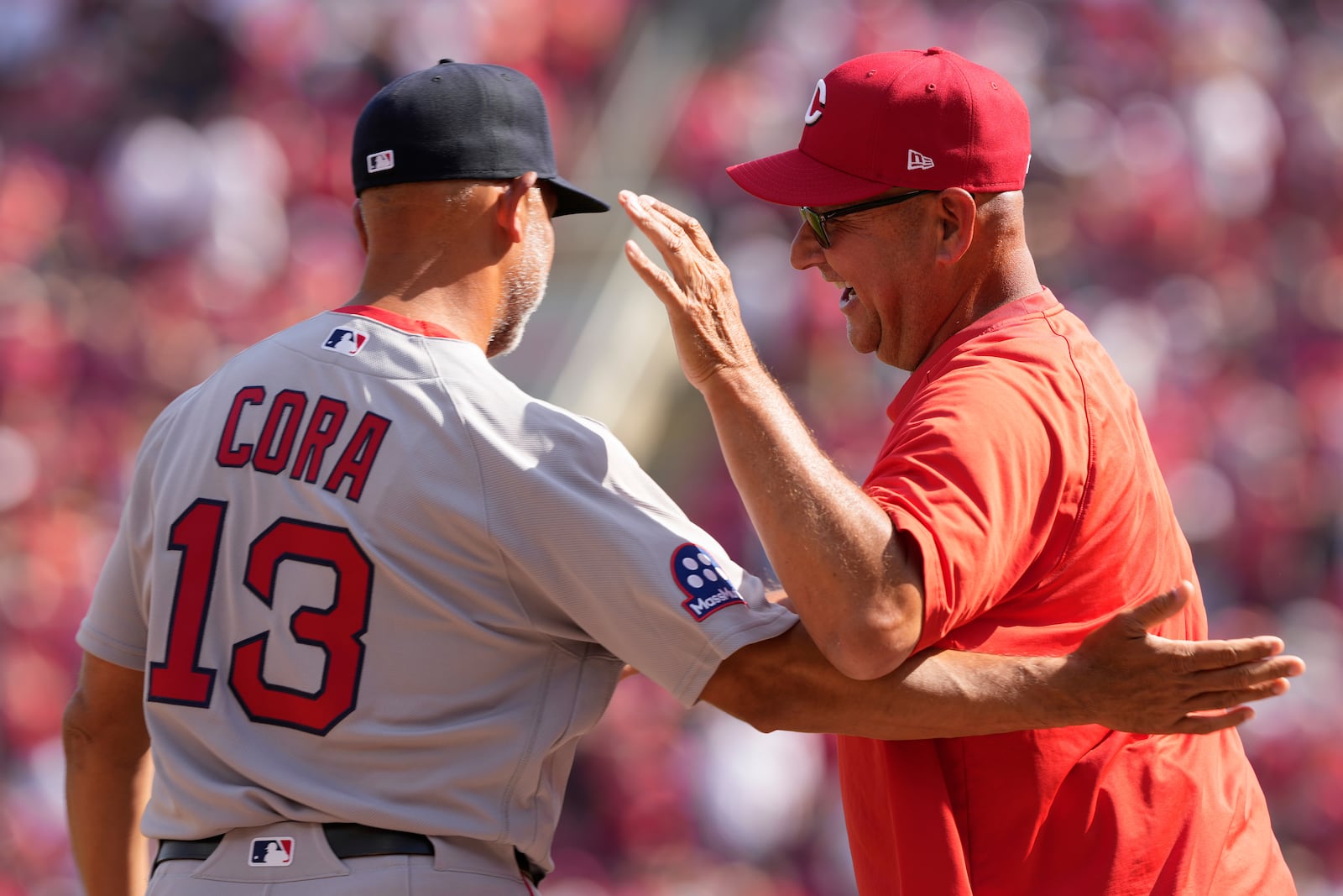 Boston Red Sox manager Alex Cora, left, Cincinnati Reds manager Terry Francona, right greet each other before an opening-day baseball game in Cincinnati, Thursday, March 26, 2026. (AP Photo/Carolyn Kaster)