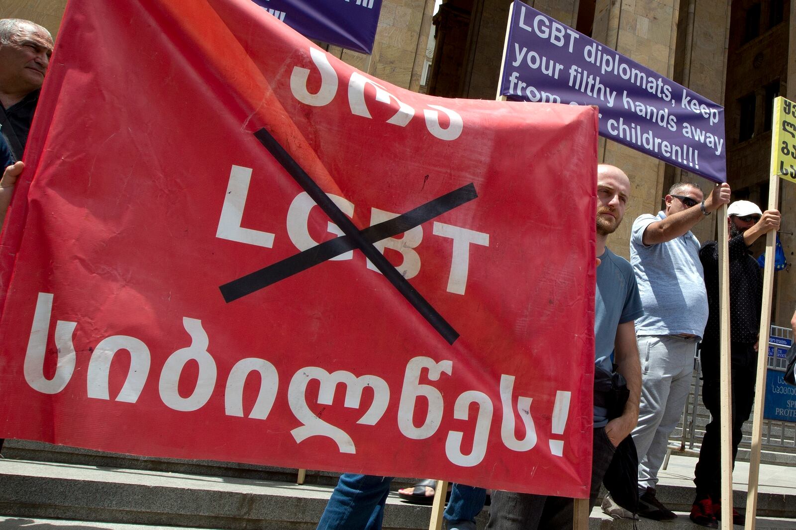 FILE - Georgian far right supporters hold a banner reading, "No to LGBT darkness," in front of parliament during a rally against Pride Week in Tbilisi, Georgia, on July 2, 2022. (AP Photo/Shakh Aivazov, File)