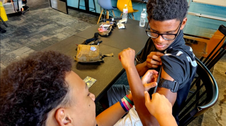 Two teenage members of Victory Project are learning how to apply a tourniquet during TACMED training. CONTRIBUTED
