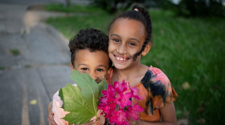 AP File - Caydence Manson and her brother, Carter Manson, who both struggle with asthma, hold flowers and leaves they found in the garden as they pose for a portrait in Hartford, Conn., on Wednesday, May 25, 2022. A 2019 analysis highlighted by the Asthma and Allergy Foundation found that exposure to pollutants - specifically, fine particulate matter - was disproportionately experienced by Black and Hispanic populations. In Montgomery County, Black children are six times more likely to be hospitalized for asthma than white children, according to Public Health - Dayton and Montgomery County. (AP Photo/Wong Maye-E)