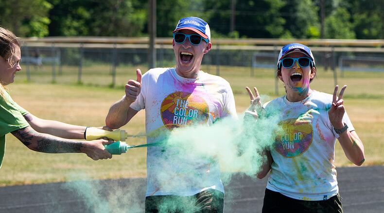 Staff Sgt. Caroline Berglin sprays a pair of runners as they circle the Jarvis track during the color run June 30 at Wright-Patterson Air Force Base. Following the color run, there were games, booths and food trucks for people to observe the end of Pride Month. U.S. AIR FORCE PHOTO/R.J. ORIEZ