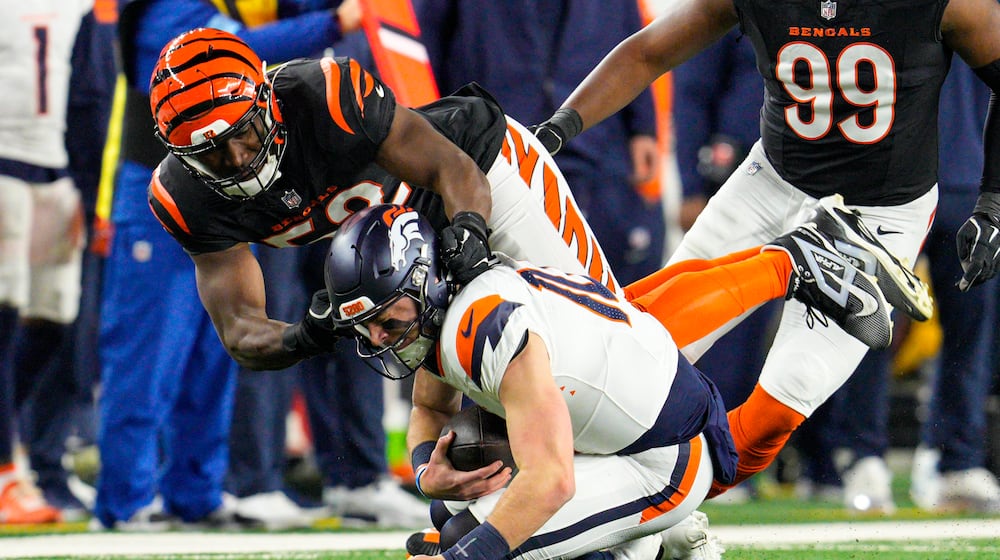 Cincinnati Bengals defensive end Cedric Johnson (52) sacks Denver Broncos quarterback Bo Nix (10) during the first half of an NFL football game in Cincinnati, Saturday, Dec. 28, 2024. (AP Photo/Jeff Dean)