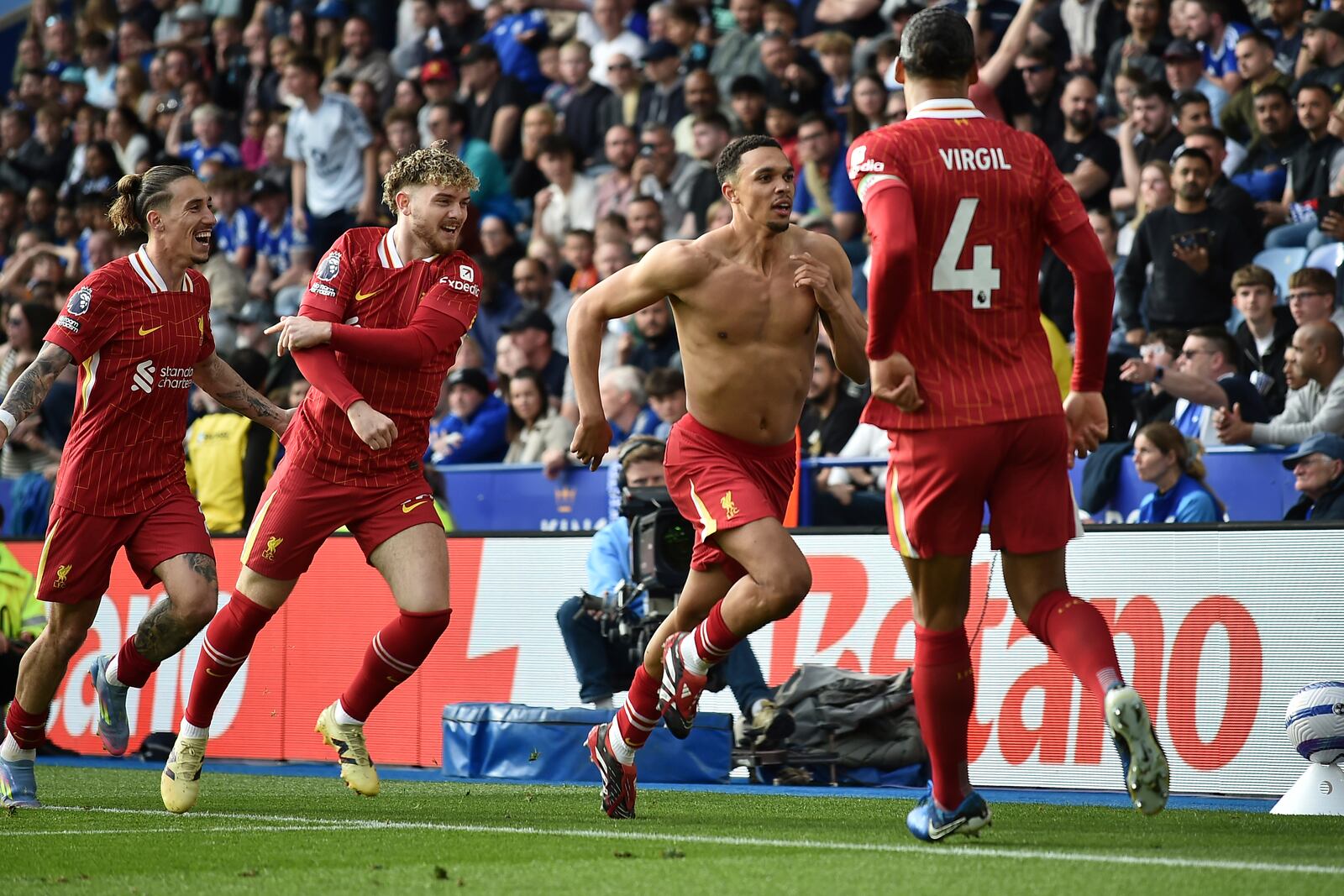 Liverpool's Trent Alexander-Arnold, second right, celebrates after scoring his side's opening goal during the English Premier League soccer match between Leicester City and Liverpool at King Power stadium in Leicester, England, Sunday, April 20, 2025. (AP Photo/Rui Vieira)