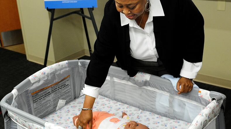 File - Community Health Advocate Angela Grayson at Public Health - Dayton & Montgomery County demonstrates the the way to help babies sleep safer on May 10, 2023 on infant mortality in Montgomery County. Parents are asked to remember the ABC's of safe baby sleep: Alone, on their Back and in a Crib. MARSHALL GORBY\STAFF