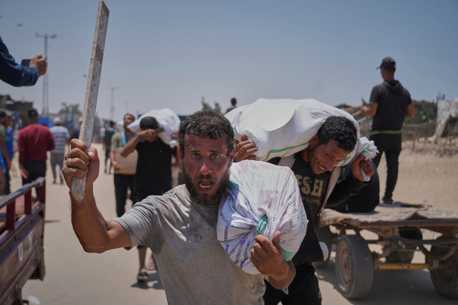 Palestinians carry bags containing food and humanitarian aid packages delivered by the Gaza Humanitarian Foundation, a U.S.-backed organization, in Rafah, southern Gaza Strip, Monday, June 9, 2025. (AP Photo/Abdel Kareem Hana)