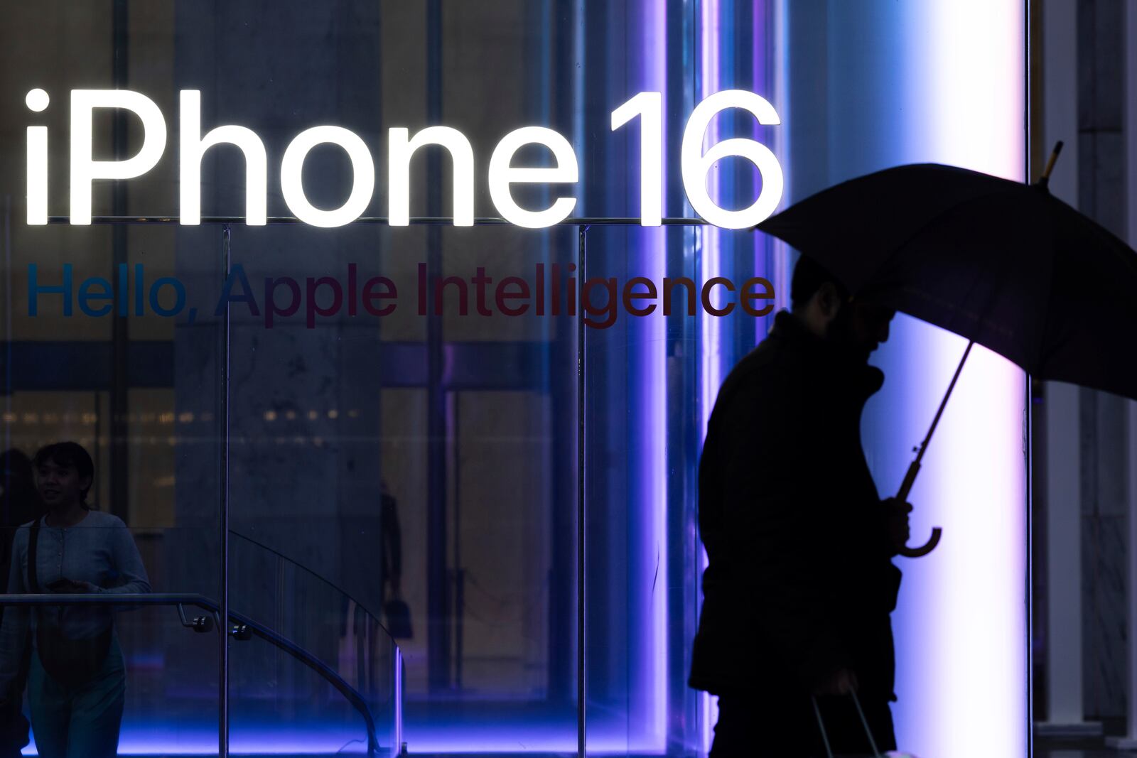 A person carrying an umbrella walks past the Apple Store on the 5th Avenue, Monday, April 7, 2025, in New York. (AP Photo/Yuki Iwamura)