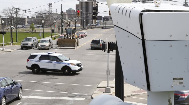 The city of Dayton is looking at reinstating its traffic camera program, which it discontinued because of stringent state requirements. These red light cameras at the intersection of West Third Street and Edwin C. Moses Boulevard in Dayton record data but do not issue fines. TY GREENLEES / STAFF