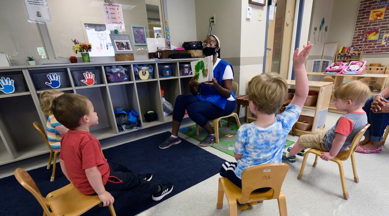 Valissa Williams, assistant teacher, Child Development Center, Wright-Patterson Air Force Base, reads a book to toddlers while adhering to COVID-19 protocols Aug. 5. Ohio Gov. Mike DeWine announced that beginning Aug. 9, child care providers in Ohio may return to their normal, statutory ratios and class sizes. There will be no immediate impact on the Wright-Patterson Child Development Centers as the installation remains in Phase 1 and in Health Protection Condition Charlie. (U.S. Air Force photo/Ty Greenlees)