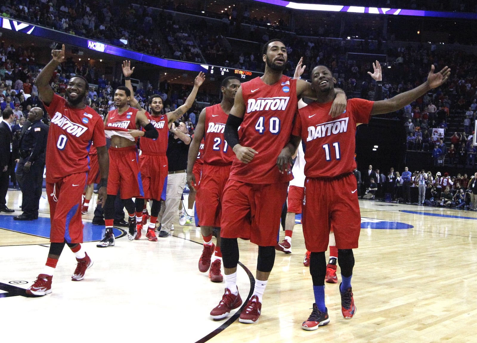 Dayton players, including Khari Price, far left, and Devon Scott, center, and Scoochie Smith, celebrate after a victory against Stanford in the Sweet 16 on Thursday, March 27, 2014, at FedExForum in Memphis, Tenn. David Jablonski/Staff