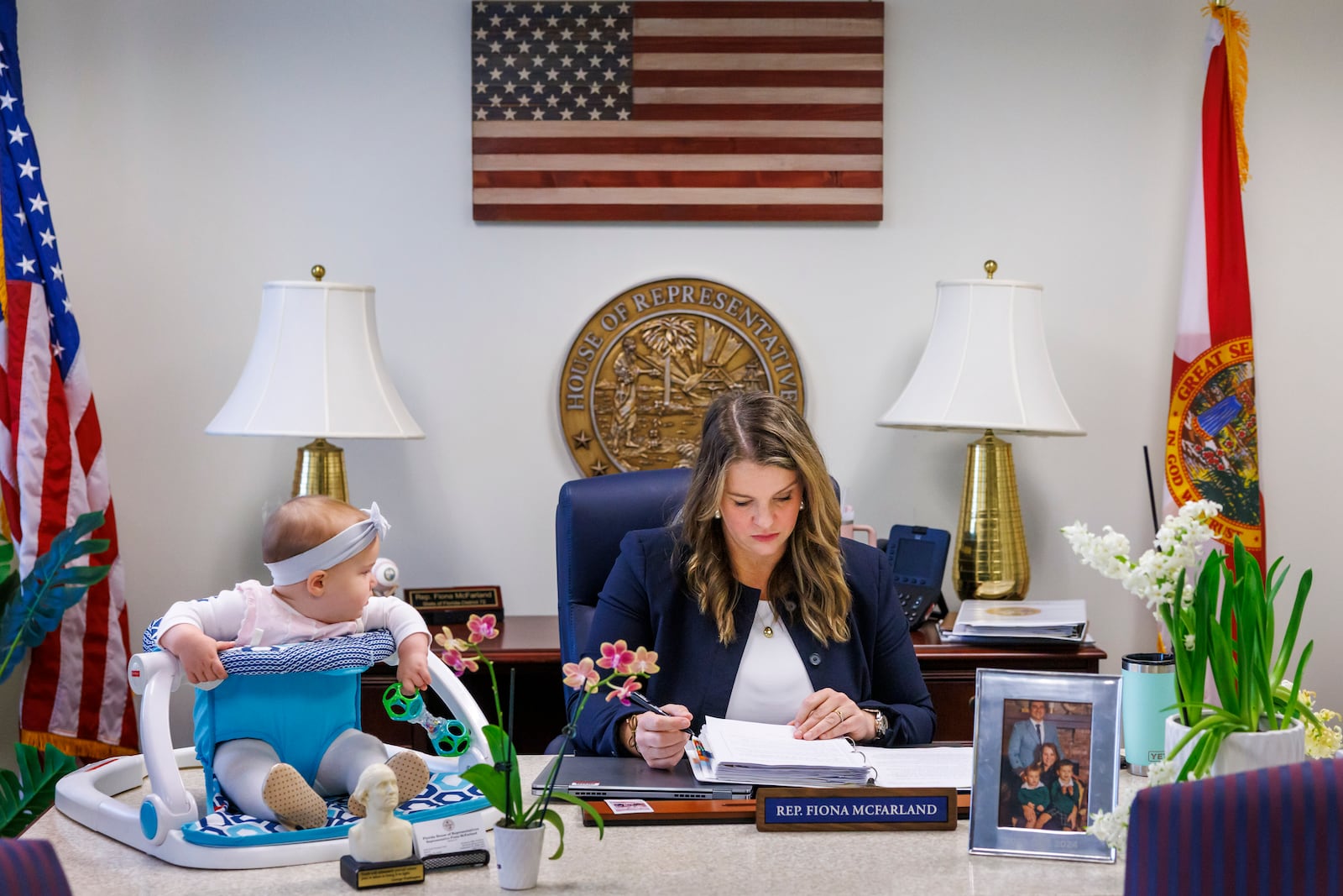 Florida Rep. Fiona McFarland, R-Sarasota, reviews a bill before committee as her 7-month-old daughter Grace Melton, left, watches, Thursday, April 17, 2025, in Tallahassee, Fla. (AP Photo/Colin Hackley)