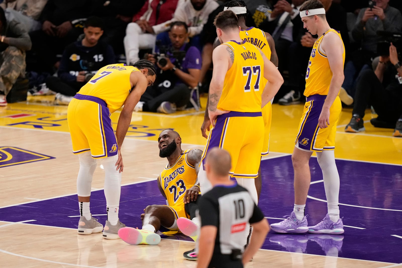 Los Angeles Lakers forward LeBron James lays on the floor after injuring his knee during the second half in Game 5 of an NBA basketball first-round playoff series against the Minnesota Timberwolves, Wednesday, April 30, 2025, in Los Angeles. (AP Photo/Mark J. Terrill)
