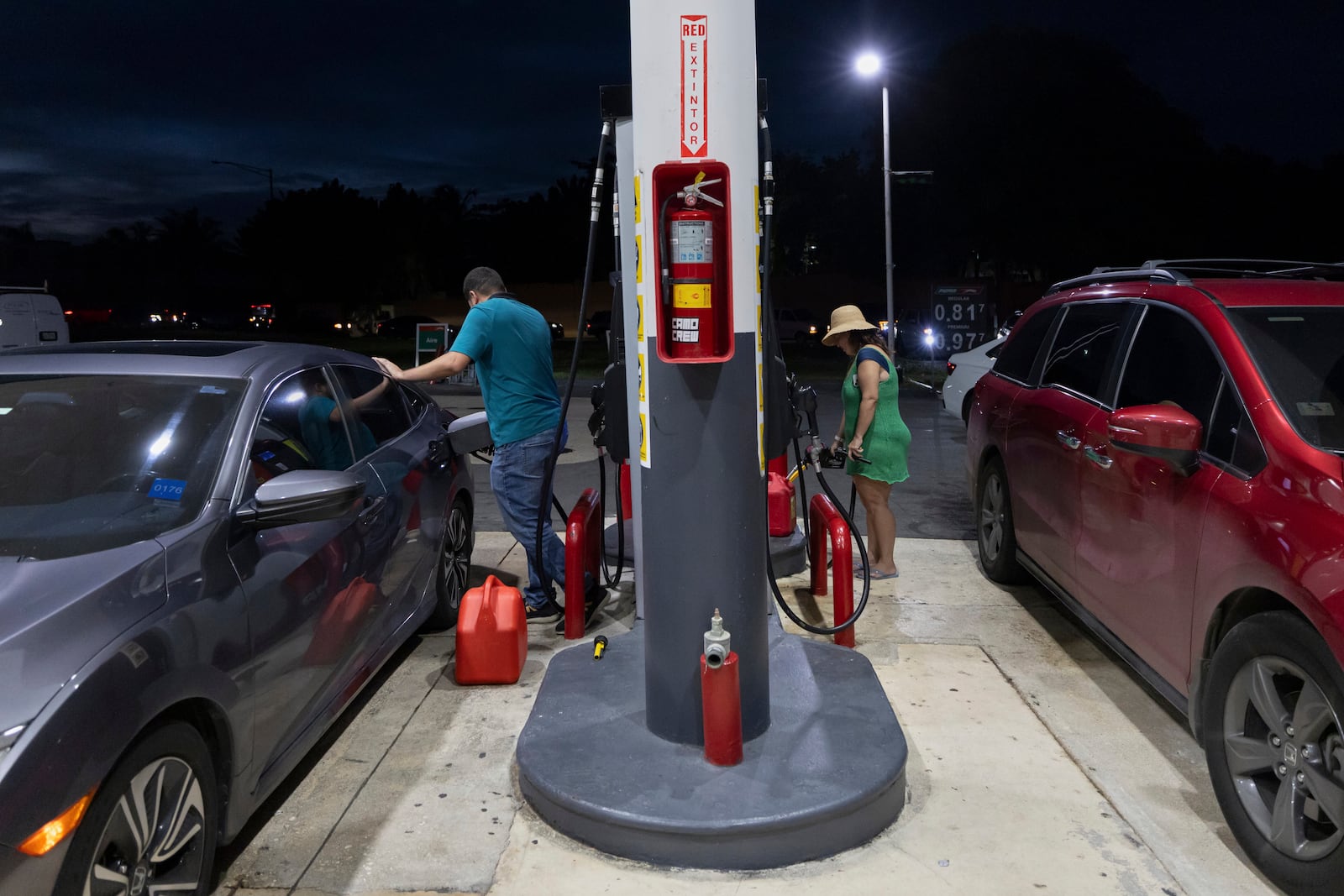 Drivers fill up fuel containers at a gas station during an island-wide blackout in San Juan, Puerto Rico, Wednesday, April 16, 2025. (AP Photo/Alejandro Granadillo)