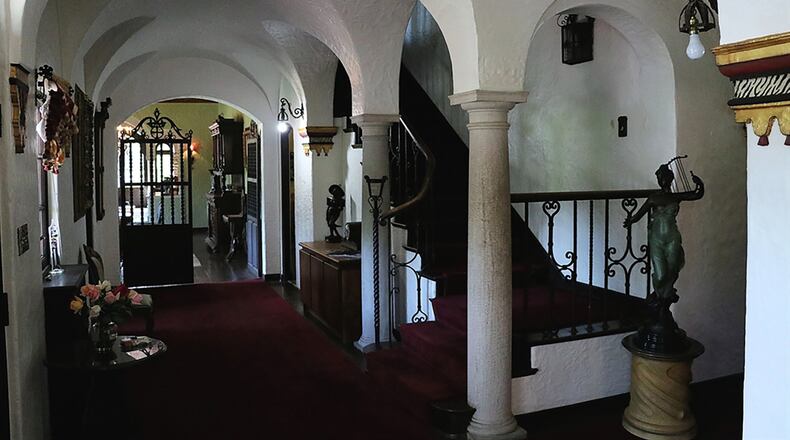 Arched double doors open into the long, arched foyer, a place to linger in amazement at multiple stucco arches, ornate gold leaf sconces and arched windows facing front.