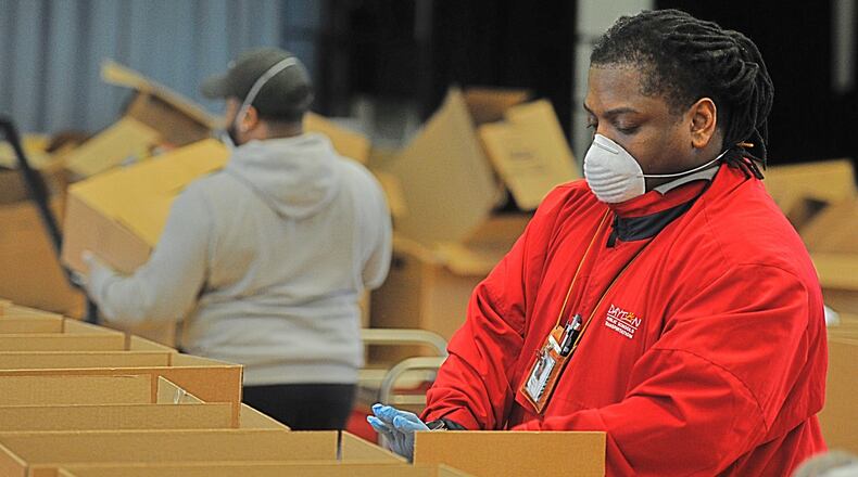 Kenny Jones Jr., with Dayton public school, packs up boxes of food at Westwood School to be delivered by buses to students. MARSHALL GORBYSTAFF