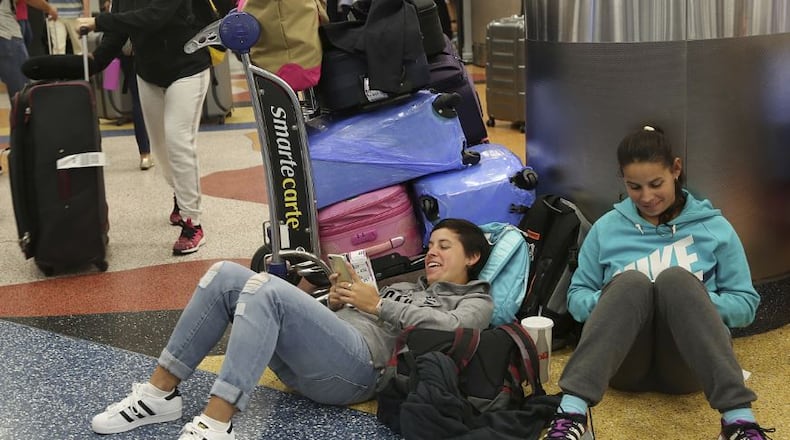 Yanina Fernandez, left, and her sister Liz, wait for an available flight to Argentina after their flight was cancelled at Miami International Airport, Thursday, Sept. 7, 2017, in Miami. South Florida officials are expanding evacuation orders as Hurricane Irma approaches, telling more than a half-million people to seek safety inland. (AP Photo/Marta Lavandier)