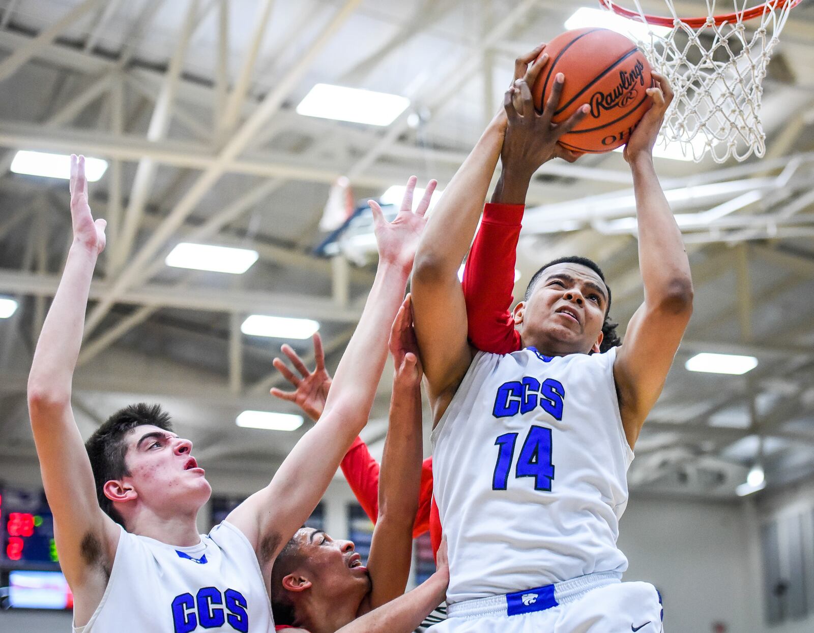 Cincinnati Christian's Christian Keese (14) and teammate Nick Hesselgesser go up for a rebound during Friday night’s Division IV regional final against Lima Perry at Fairmont’s Trent Arena. NICK GRAHAM/STAFF