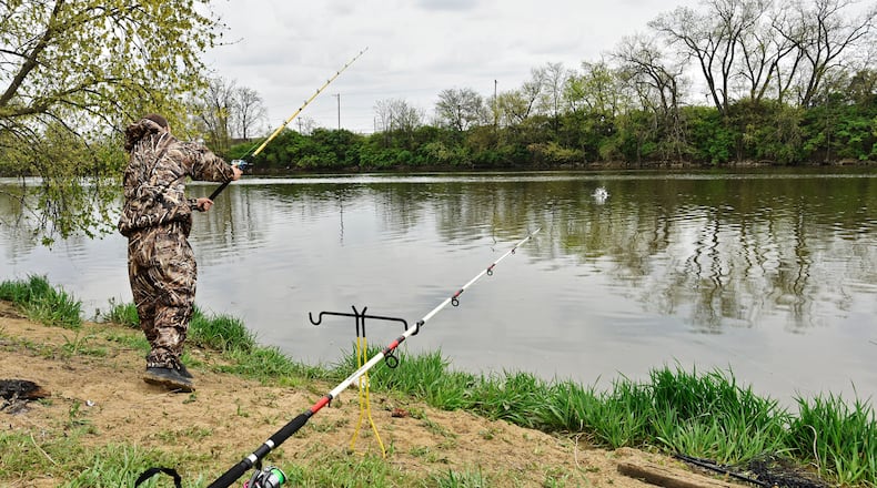 Nick Griffith fishes along the bank of the Great Miami River at Combs Park in Hamilton. STAFF FILE PHOTO/2016
