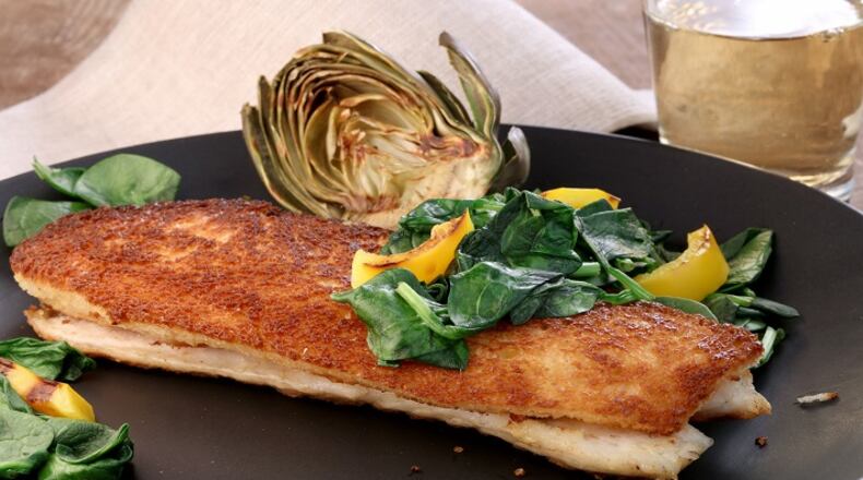 Branzino en croute is created by pan-frying fillets of the fish with planks of bread. (Michael Tercha/Chicago Tribune/TNS)