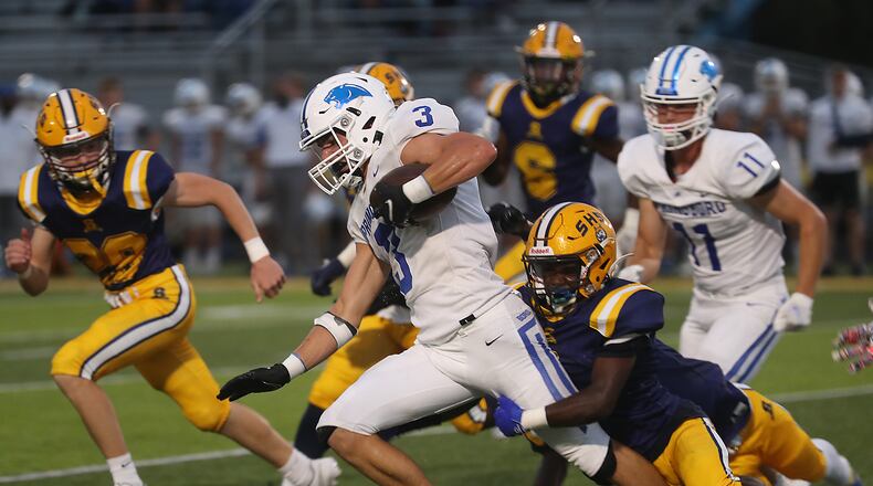 Springboro's Titan Case is tripped up by Springfield's Dovon Williams as he carries the ball. BILL LACKEY/STAFF