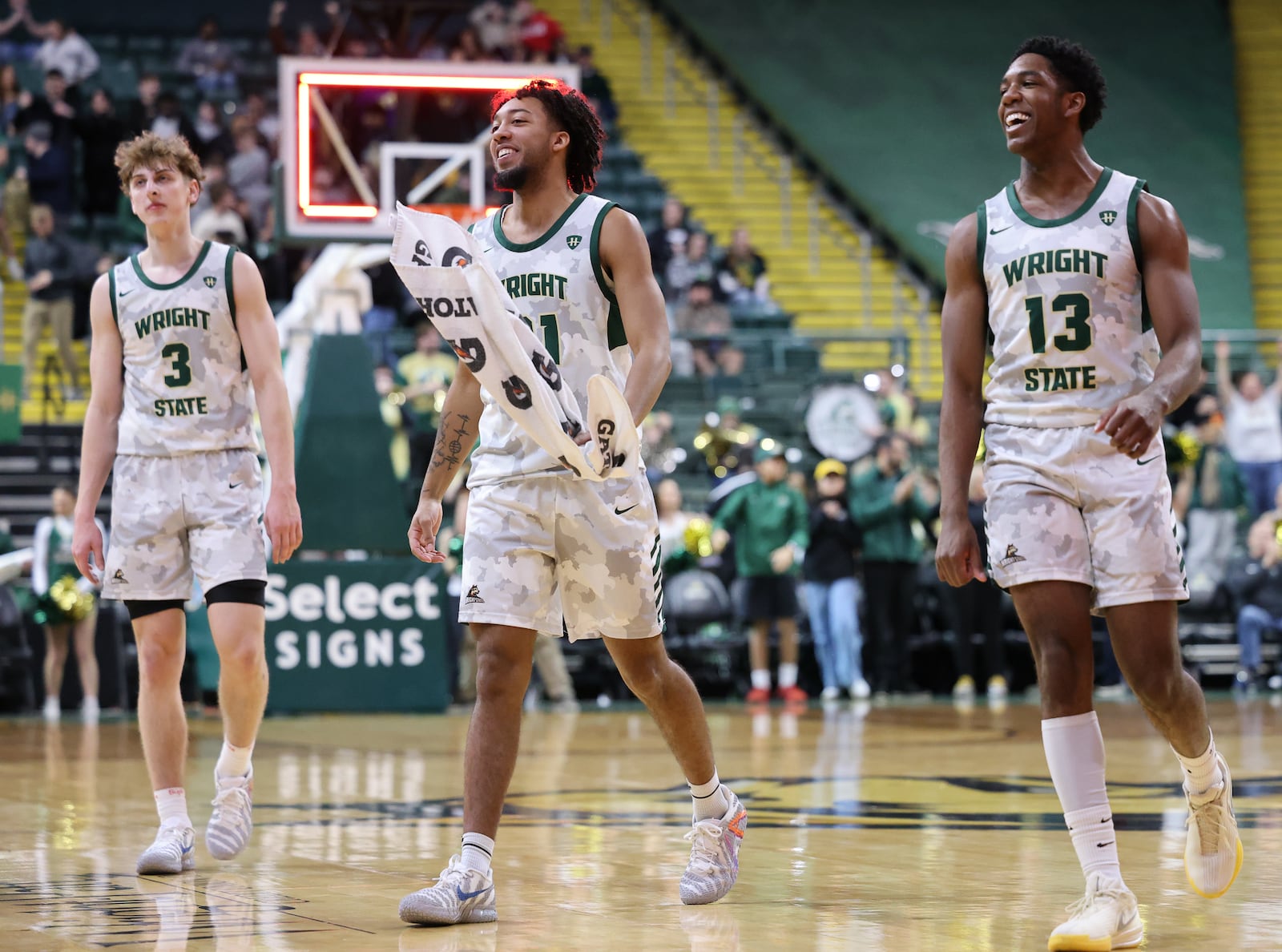 Wright State's Logan Woods (center) celebrates while walking off the court with Dominic Pangonis (left) and Solomon Callaghan (right) after defeating Youngstown State 93-83 in a Horizon League game on Thursday, Jan. 15 at Ervin J. Nutter Center. BRYANT BILLING / STAFF