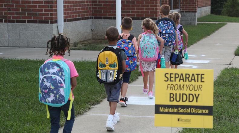 Students practice social distancing as they walk into Simon Kenton Wednesday for the first day of school. BILL LACKEY/STAFF