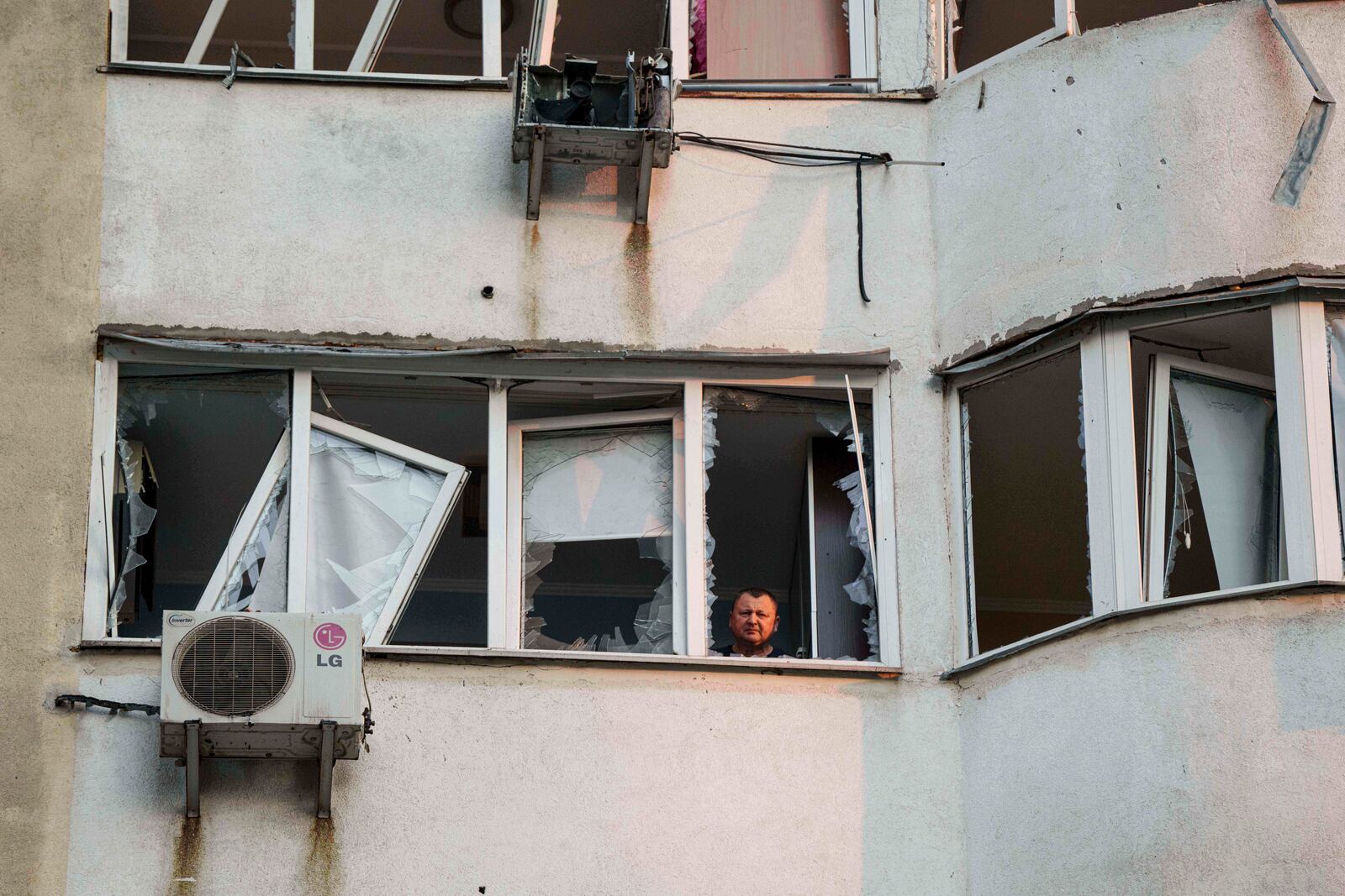 A man looks from a window of a residential multi-storey building damaged after a Russian drone strike on Kyiv, Ukraine, on Friday, June 6, 2025. (AP Photo/Evgeniy Maloletka)