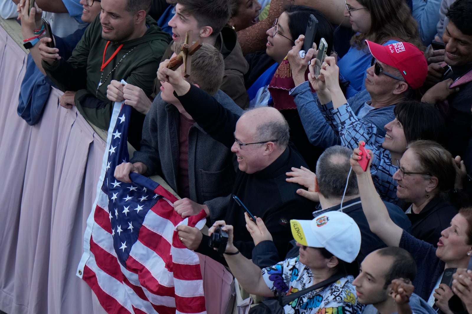 People react after Cardinal Dominique Mamberti announced the election of Cardinal Robert F. Prevost as the 267th pope, choosing the name of Pope Leo XIV, at the Vatican, Thursday, May 8, 2025. (AP Photo/Luca Bruno)